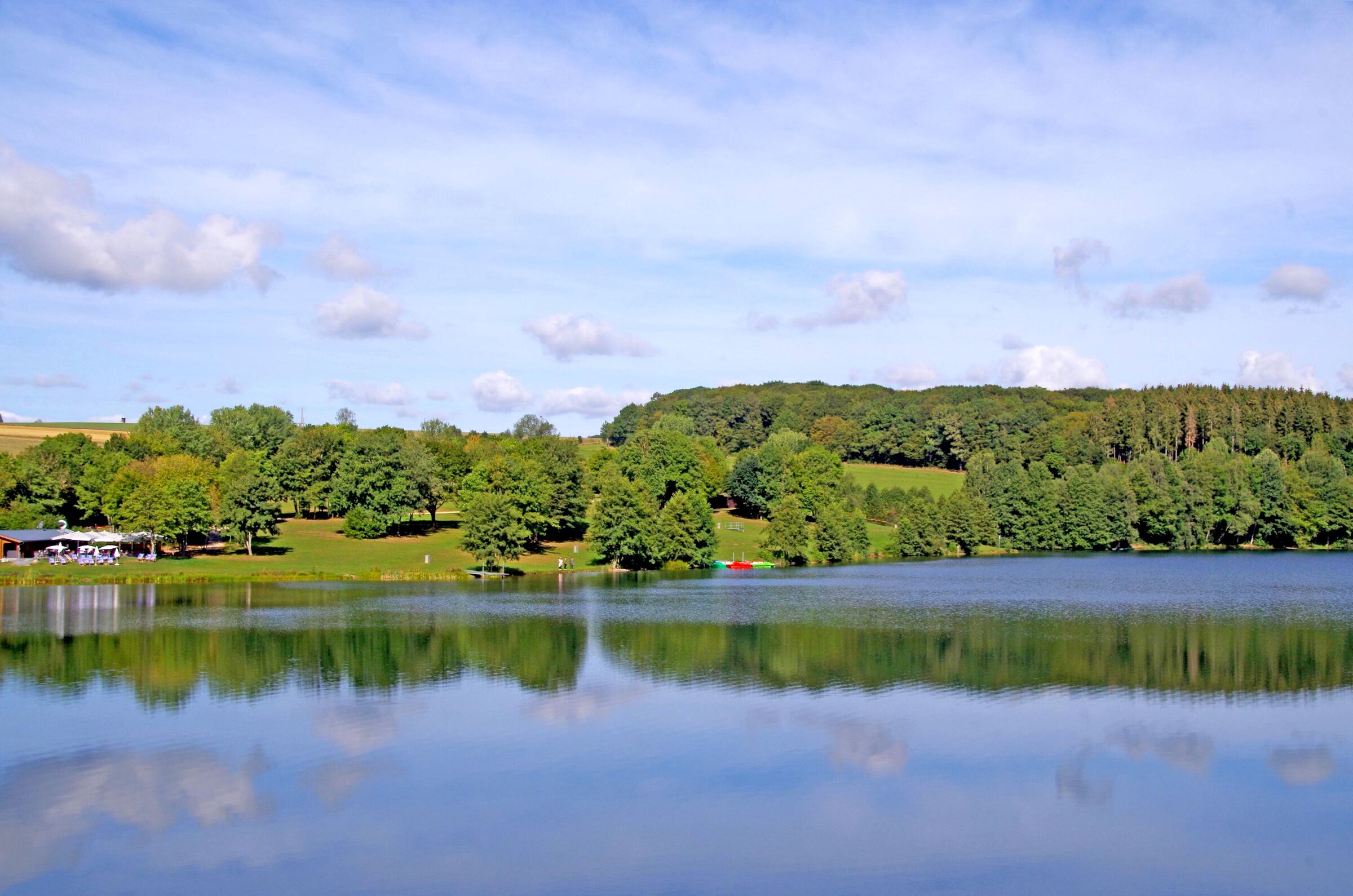 Der Freilinger See mit Spiegelung der bewaldeten Hügel